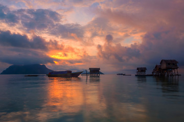 Fototapeta na wymiar A cloudy sunrise at the sea gypsy village in Maiga Mabul Sipadan island, Semporna, Sabah, Malaysia.