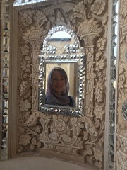 Donna con velo riflesso in specchio decorato di arte persiana