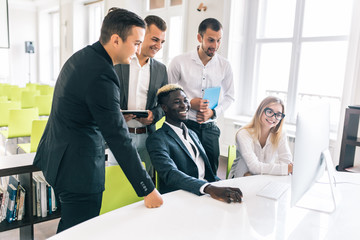 Team of casual business meeting to discuss ideas and computer on table in office.