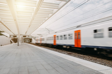 Fototapeta na wymiar Zug fährt schnell am abstrakten Bahnhof