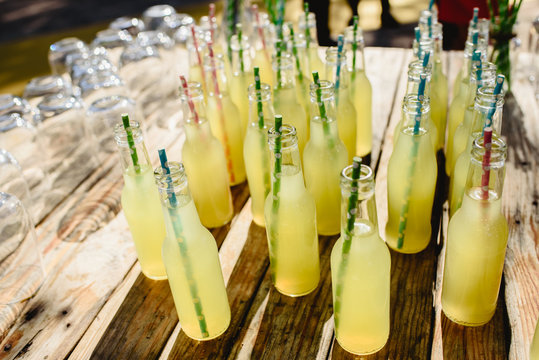 Group of glass bottles with straws with natural lemonade and fresh homemade.