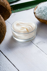 coconut moisturizer cream and bath salt , on white wood table
