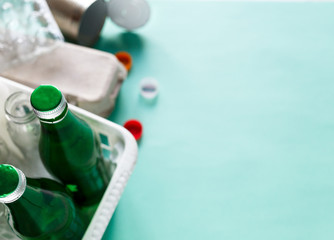 different wastes ready for recycling in white basket. Plastic bottles, glass, egg tray. Social responsibility, ecology care, recycling at home concept