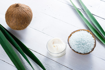 coconut moisturizer cream and bath salt , on white wood table