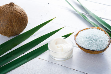 coconut moisturizer cream and bath salt , on white wood table