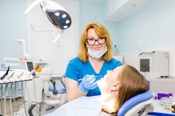 Dentist therapist treats the client's teeth in a dental clinic