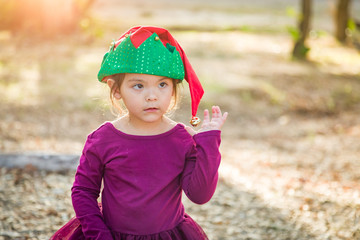 Cute Mixed Race Young Baby Girl Having Fun Wearing Christmas Hat Outdoors