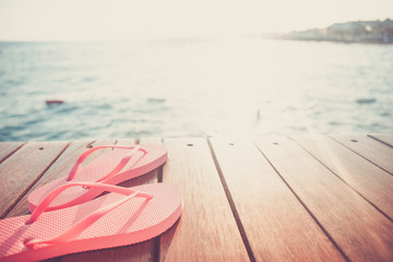 Flip flops at the wooden pier during sunset. Luxury vacation resort. Holiday getaway concept