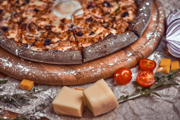 Pizza on wooden background with tomatoes, mushrooms,  basil and mozzarella cheese, close up top view