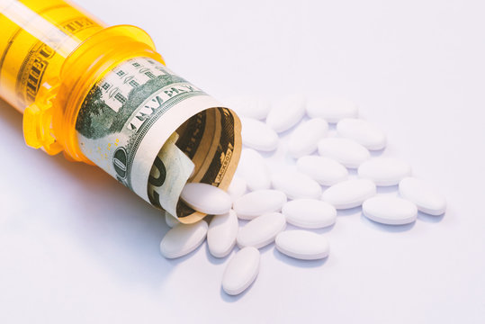 money and pills in pill bottle and stethoscope on table medical expense concept