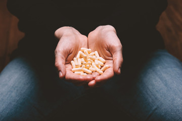 female holding capsule pills in hand