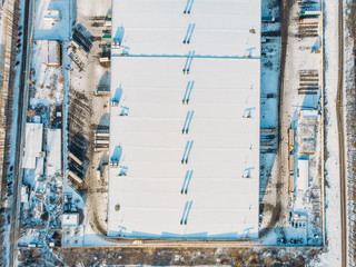 Aerial view of warehouse storages or industrial factory or logistics center from above. Top view of industrial buildings and trucks