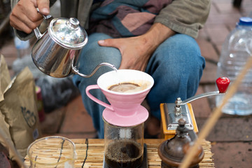 Barista making drift hot coffee in day market.