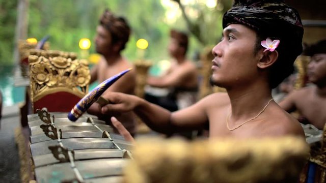 Asian Balinese musician gamelan group playing in traditional dress in a ceremonial celebration performance Indonesia South East Asia
