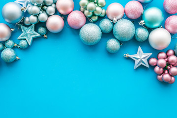 Toys for New Year tree 2019 background. Blue and pink balls and stars on blue background top view copy space border