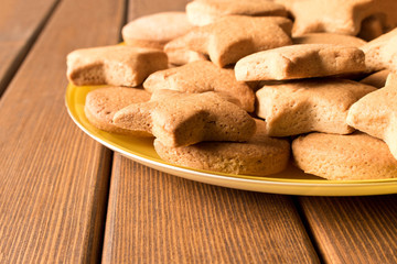 Freshly made cookies in a yellow plate on a wooden table. Close up