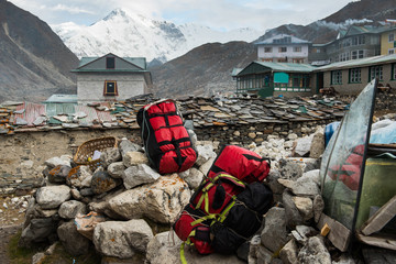 Red duffel tie together and put on rock in village in everest base camp route region,Nepal
