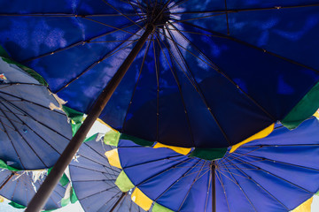 Blue beach umbrellas for sun protecrion closeup background.