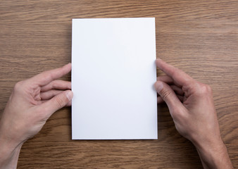 Obraz premium Mens hands holding empty white letterhead 