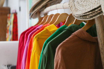 
Variety of colorful shirts hanging on the wooden hangers, close up 