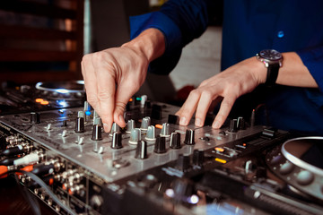Dj mixes the track in the nightclub at party