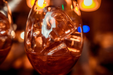 Glass of orange cocktail on bar background