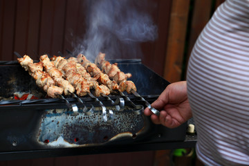 Meat And Vegetable Kebabs On The Hot BBQ Grill. Flaming Charcoal In The Background. Snack For Outdoor Summer Barbeque Party. Family dinner in the open air.