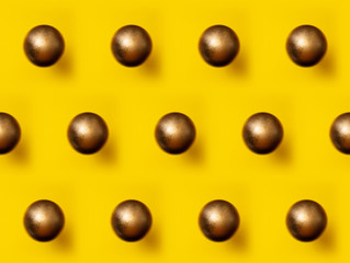 Golden Christmas ball pattern on yellow background