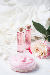 cosmetic cream with pink roses on a wooden table