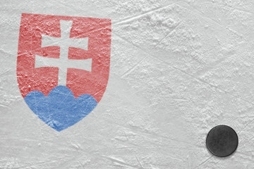 Hockey puck and the image of the Slovak coat of arms on the ice of the stadium