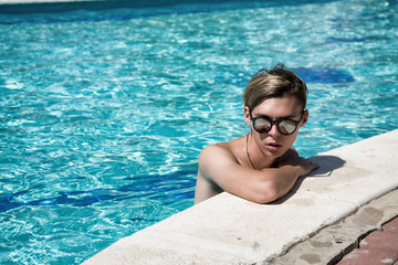 Young attractive guy. Summer, relaxation and pool.  