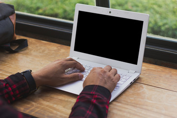 man hand typing labtop computer with blank screen black for mock up, technology and lifestyle...