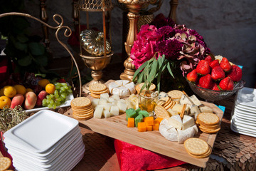 event reception with appetizers, caviar and crackers, cheese and fruit decorated with flowers