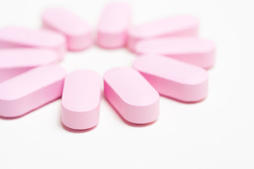 Obraz na płótnie Canvas Pink medicine vitamin pills on white