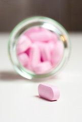 Pink medicine vitamin pills on white