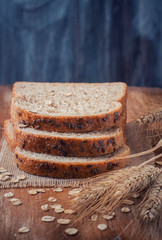 Healthy wholegrain bread on burlap napkin,  located on wood back