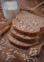 Healthy wholegrain bread on burlap napkin,  located on wood back