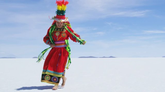 Traditional Bolivian dance performed proudly by Indigenous South American female on Salar de Uyuni Salt flats wearing traditional costume 