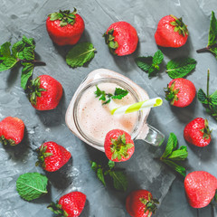 strawberry smoothie with mint in a glass with a straw on the table, top view