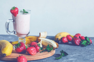 banana and strawberry smoothies with mint on the table, front view