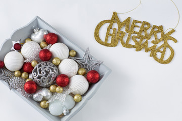 Christmas decorations in a wooden gray tray: balls, hearts, stars and written in gold letters Merry Christmas