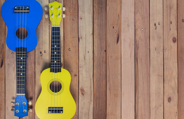 Photo shot of guitar, ukulele on wooden background. Music card, picture, poster.