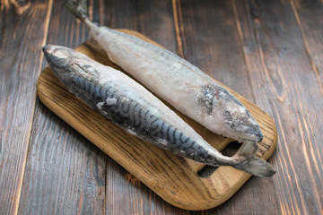 Frozen mackerel fish on wooden background.