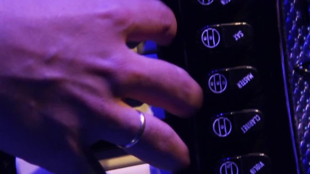 Energetic extreme close up of a man playing accordion keyboard, on a braziliam music festival during the june party