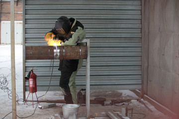 Worker welding metal piping using tig welder