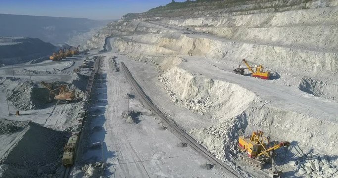 aerial motion over mining site with excavators and train