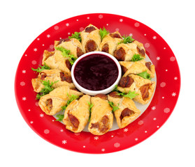Savoury pigs in blankets with cranberry sauce dip isolated on a white background