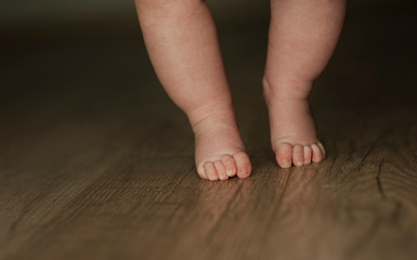 legs of newborn baby close up on isolated wooden background