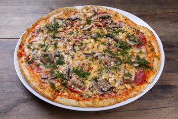Pizza with mushrooms on a wooden table