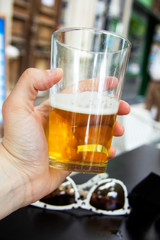 Mano sujetando un vaso de cerveza